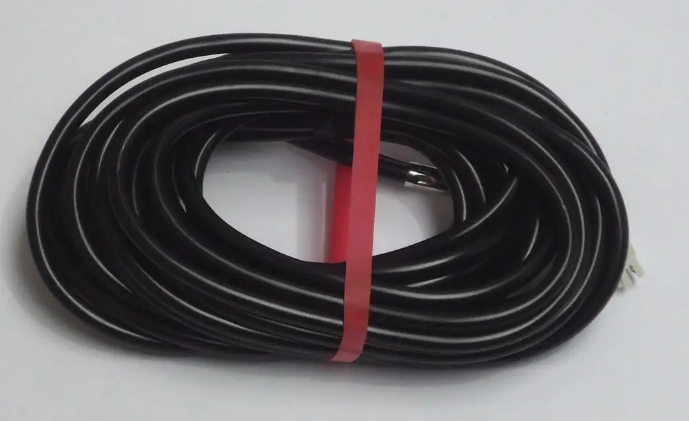 Schwarzes Kabel, ordentlich gewickelt und mit einem roten Band gesichert, mit einem Stecker, vermutlich für Geräte von Daikin.
